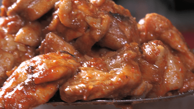Spicy stir-fried chicken scooped with a spatula