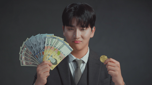 Man smiling at the Bitcoin in his hand