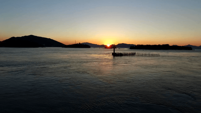 Sunset over a calm sea with distant islands