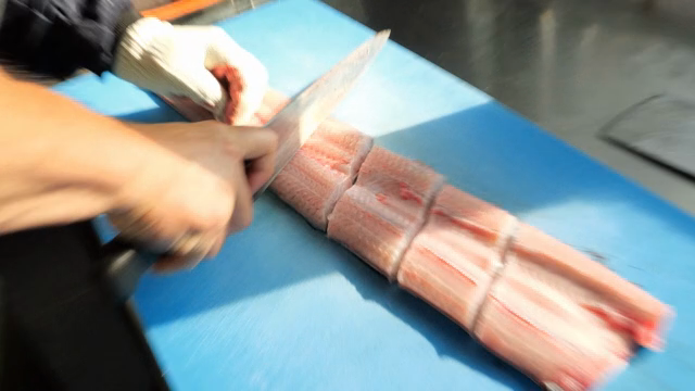Prepared eel being cut on a cutting board