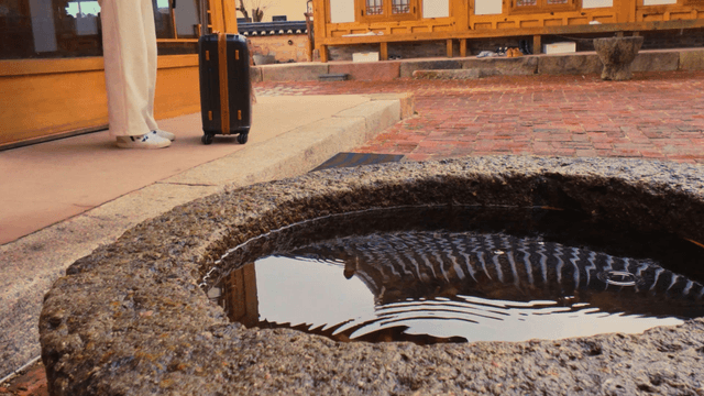 Rain falls on a Korean-style house with a travel bag outside
