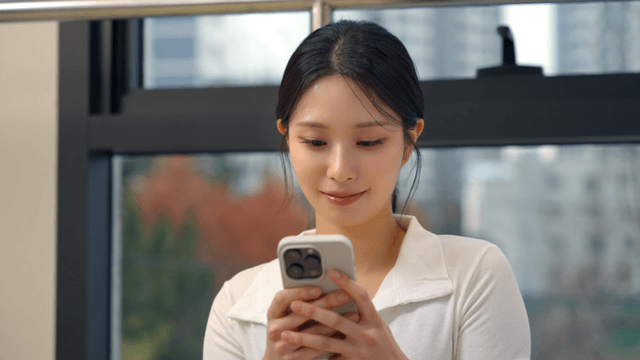 Woman smiling while using a smartphone