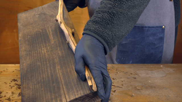 Person crafting wood indoors