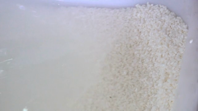 Rice being washed in a bowl of water