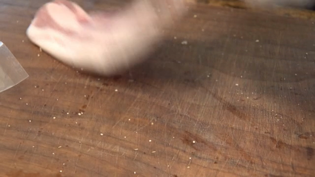 Raw pork belly seasoned on a wooden cutting board