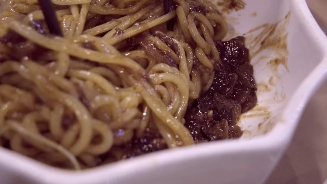 Noodles in Black Bean Sauce being mixed in a bowl