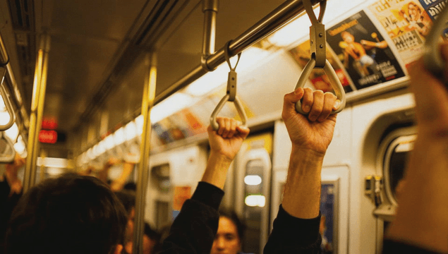 People holding subway handles