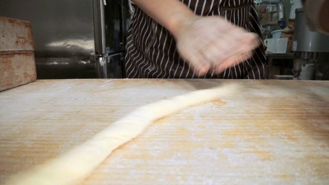 Hands kneading dough on a floured surface