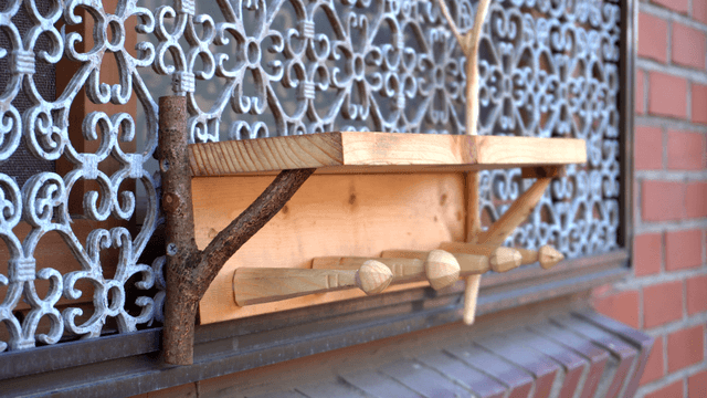 Wooden shelf attached to a decorative window