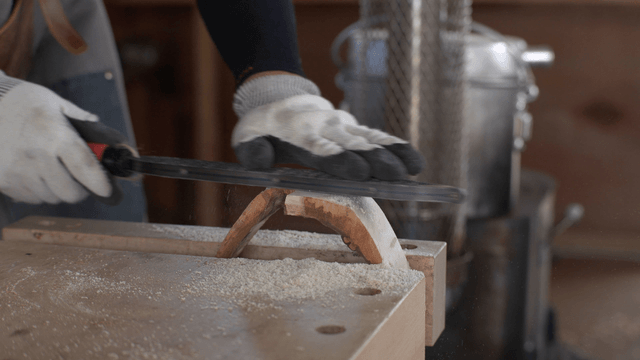 Woodworker using a rasp in workshop