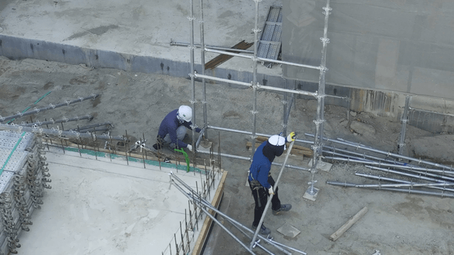 Construction workers assembling scaffolding