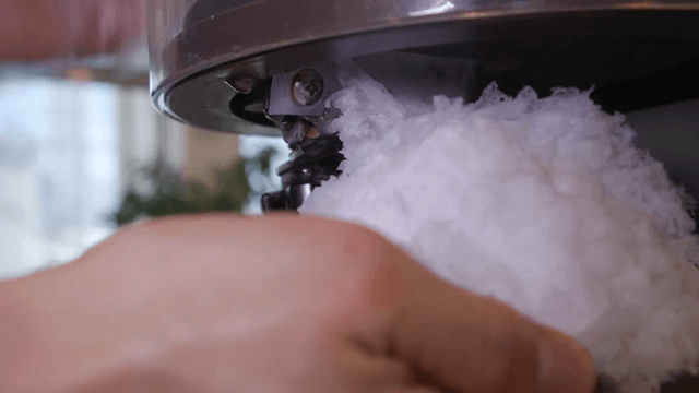 Shaved ice being prepared with a machine