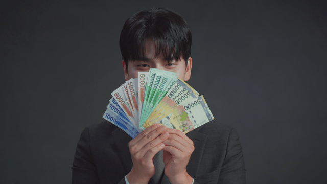 Man holding Korean banknotes with a smile