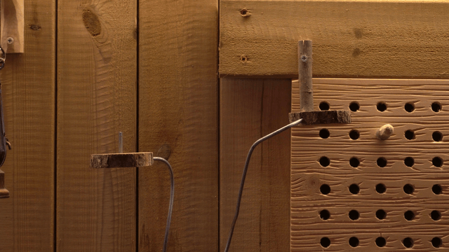 Wooden board with metal rods and holes in workshop