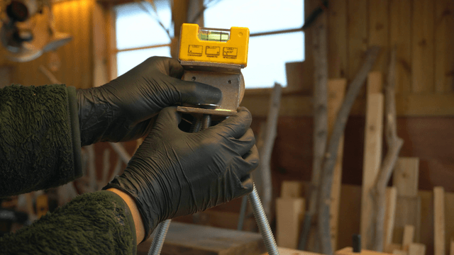 Hands adjusting the level of a bracket in workshop