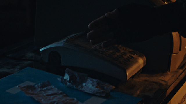 어두운 방에서 먼지 묻은 전화기를 향하는 손