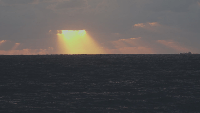 Sunlight breaking through clouds over the sea