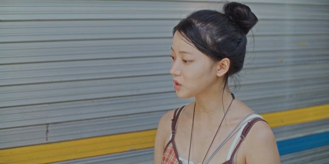 셔터 앞에 서서 말하는 여성