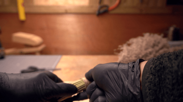 Hands crafting a broom with natural materials