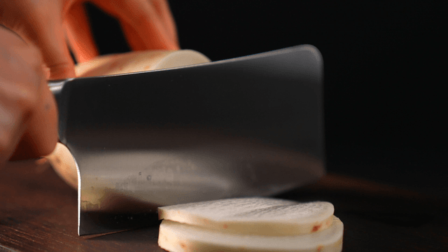 Slicing a fresh radish on a wooden board