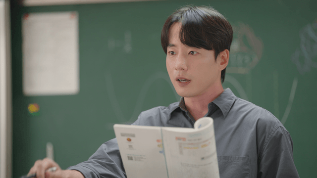 수업 중 교과서를 설명하는 교사