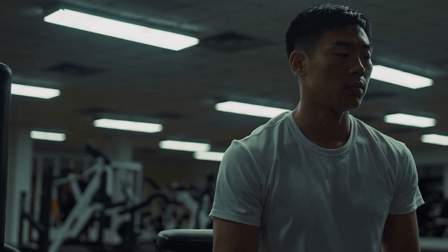 A man in a gym resting after exercise