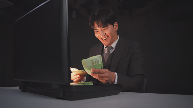 Man in a suit opening a briefcase with money