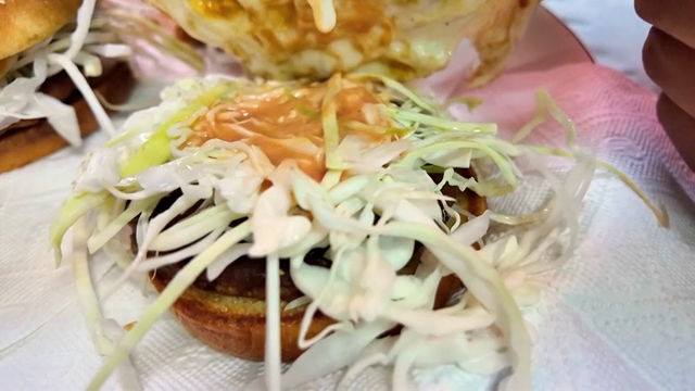 Preparing a burger with cabbage and sauce