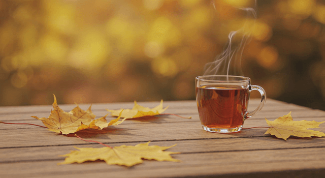 A steaming cup of tea on a wooden table