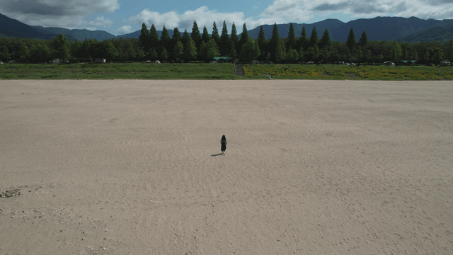 넓은 모래밭을 걷는 여성