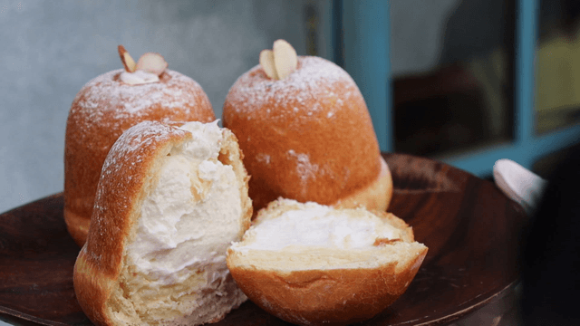 Cream-filled pastries on a wooden plate