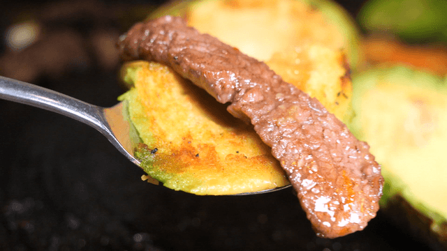 Grilled avocado with beef slice on a spoon