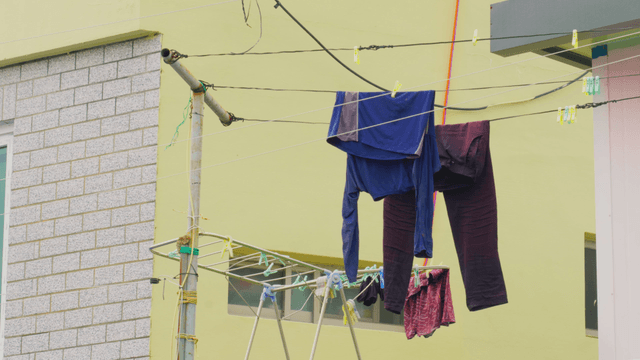 건물 밖 빨랫줄에 걸린 옷들