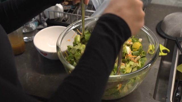 Mixing a fresh vegetable salad in a bowl