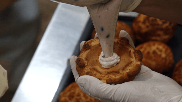 Cream being piped into a pastry