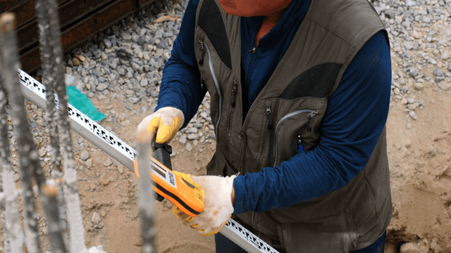 Worker using a measuring tool at a site
