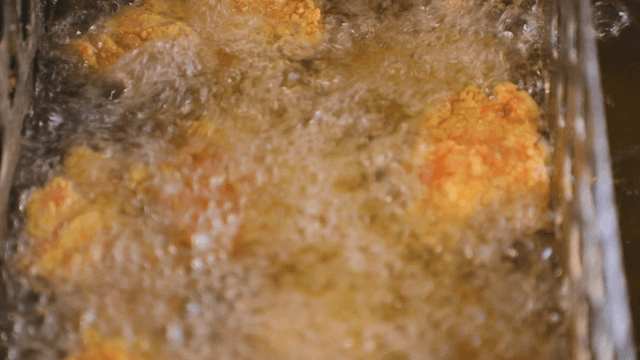 Fried chicken sizzling in hot oil
