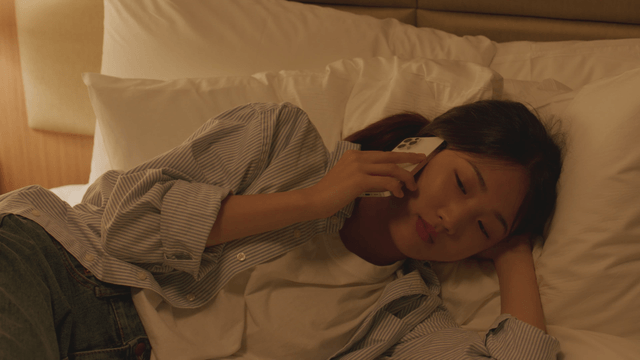 Woman talking on the phone while lying in bed