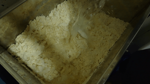 Ice water being poured into dough