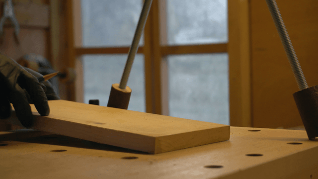Hand marking position on wood with pencil in cozy workshop