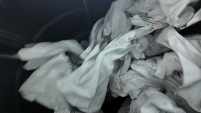 White laundry spinning in large washing machine