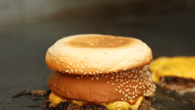 Cheeseburger cooking on hot grill