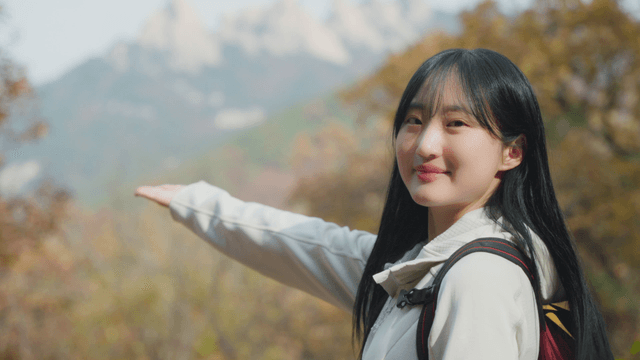 Young woman smiling while enjoying autumn mountain scenery