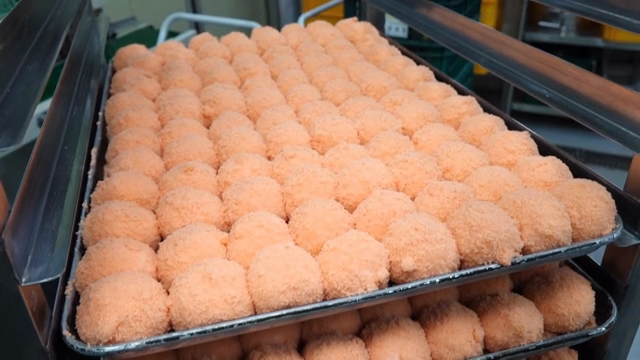 Pink rice cake being prepared on a tray