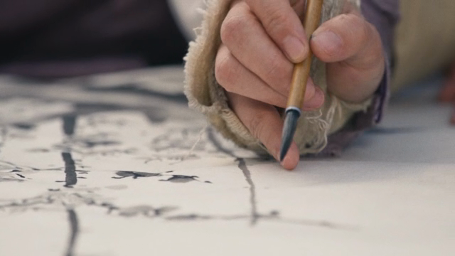 A person painting with a brush on paper