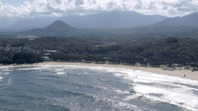 Serene beach with waves and mountains