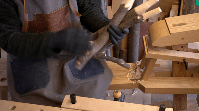 Artisan gathering polished wooden branches in workshop