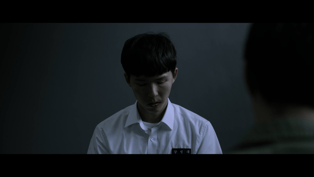 Male student being interrogated in dark room