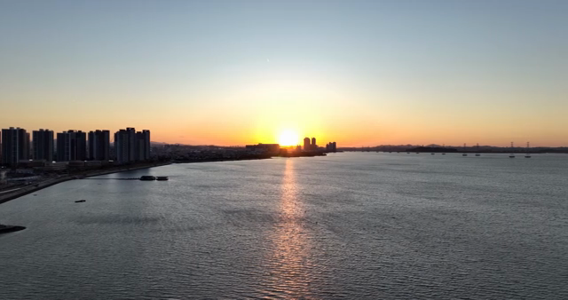 Sunset over a city skyline by the sea