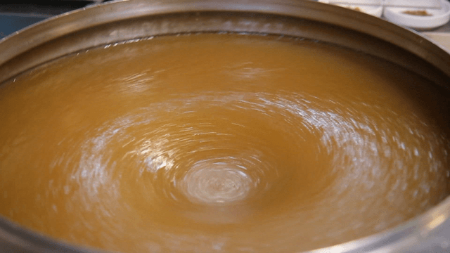 Broth being mixed in a large pot